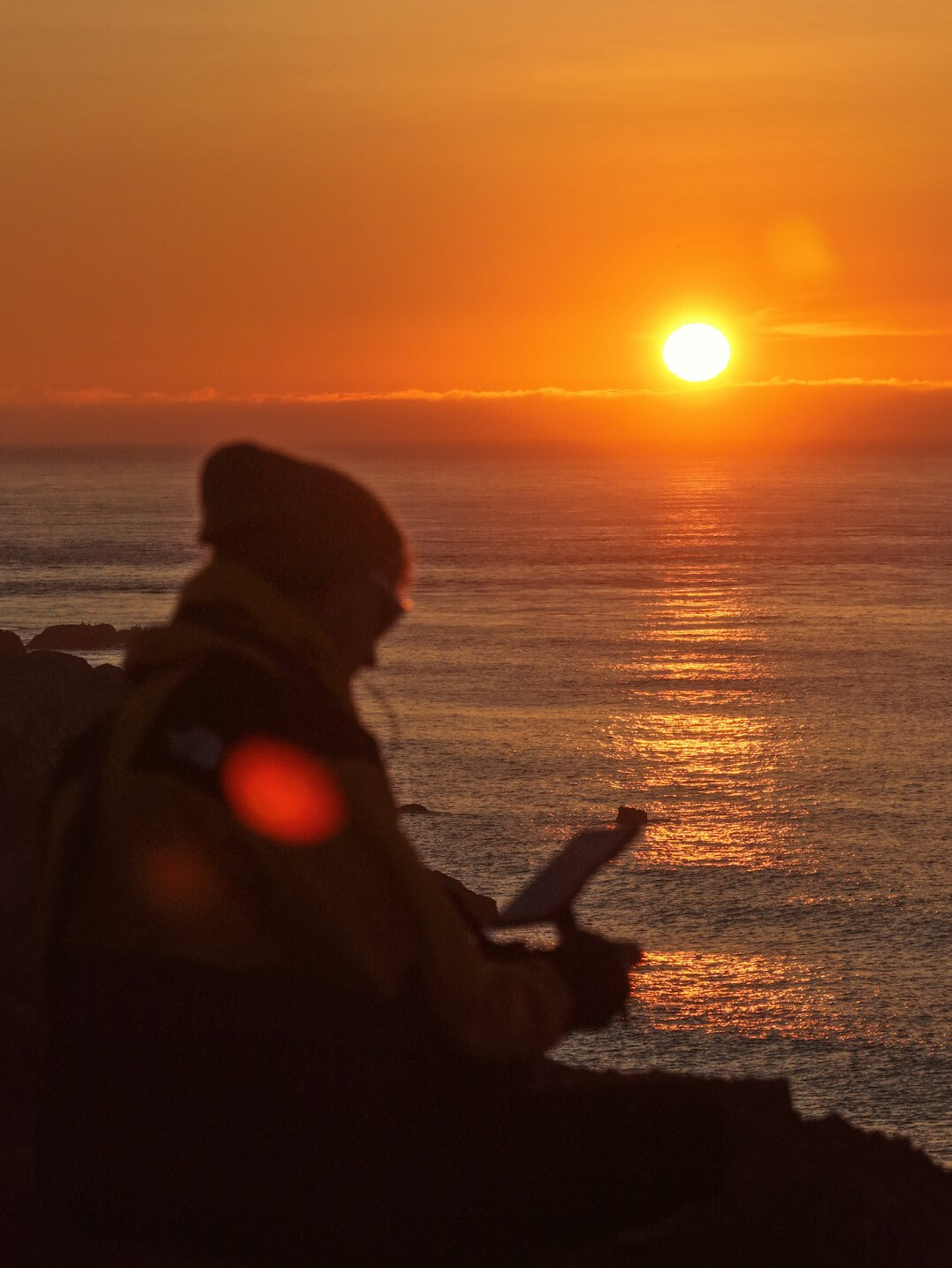 person writing in journal at sunrise